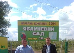 Олександр Фоменко (ліворуч), Роман Яковенко (праворуч) на фоні яблуневого саду ВАТ "Аграрна компанія 2014"